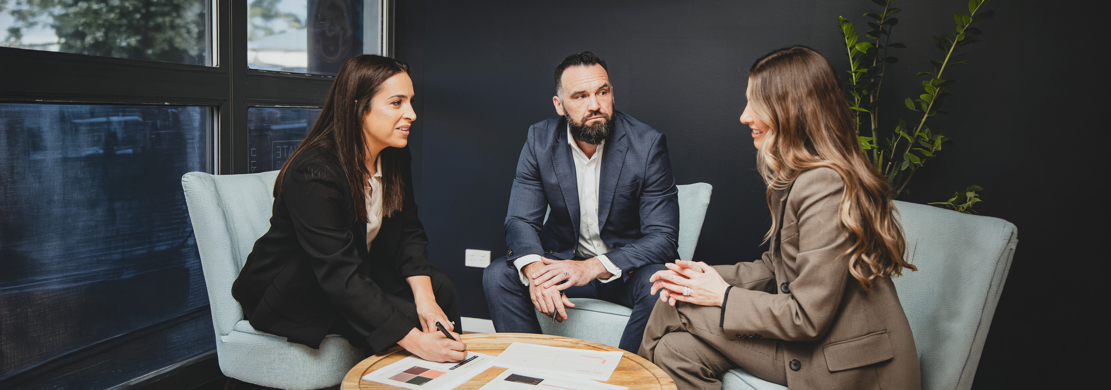 Three colleagues in discussion around a coffee table
