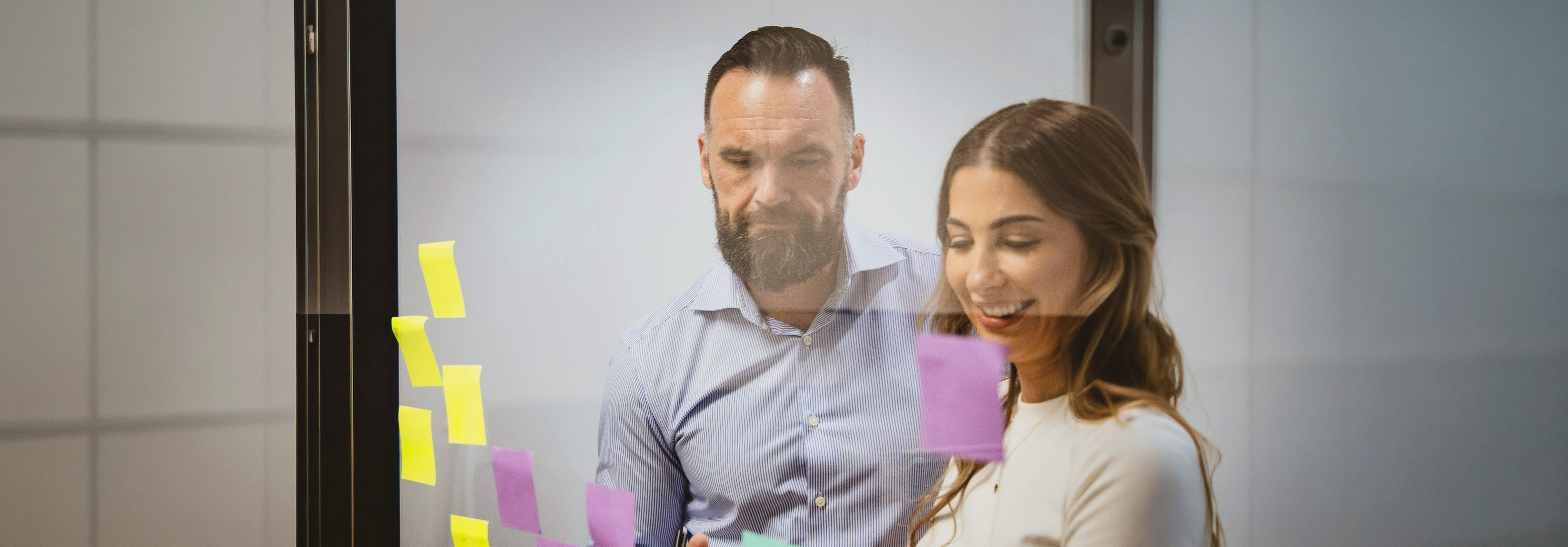 Colleagues mapping a problem on a sticky-note wall in a working session